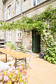 Garden table and climbing plants in sunny courtyard