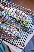 Fish stuffed with herbs in grilling baskets