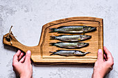Fresh pike on a wooden board in hands