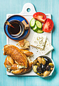 Turkish traditional breakfast with feta cheese, vegetables, olives, simit bagel and tea
