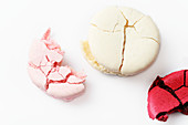 Various broken macaroons on a white suface