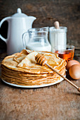A stack of crepes with honey
