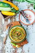 A spiral tart with green and yellow zucchinis