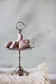 Gingerbread hearts on cakes stand and Oriental lanterns on folded blanket