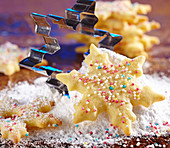 A shortbread snowflake biscuit with sugar sprinkles and icing sugar