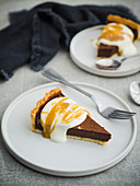 A slice of chocolate tart with cream and salted caramel sauce