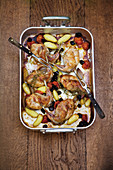 Rabbit legs with potatoes, cherry tomatoes, olives and rosemary