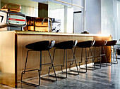 Kücheninsel aus poliertem Messing mit Barhockern in elegantem, offenem Wohnraum mit Marmorfliesen