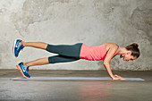 A young woman performing a three-point push-up