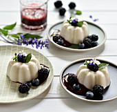 Vegan lemon and coconut pudding with blackberry sauce, fresh blackberries and blueberries