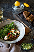 Pan fried hake with tomatoes, olives and garlic served with griddled sourdough and salad