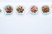 Four different salads with tomatoes