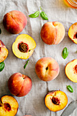 Fresh peaches and peach halves in a linen tablecloth