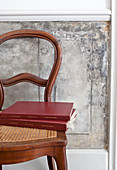 Books on antique chair with cane seat