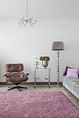 Classic armchair, serving trolley, standard lamp and grey sofa in living room