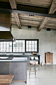Open-plan, industrial-style kitchen-dining area with high ceiling