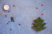 Weihnachtsdekoration: Teelicht, Beeren und Tannenbaum aus Moos