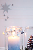 Weckgläser mit Kerze, Zapfen und Sternengirlande als Weihnachtsdeko