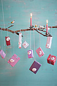 Advent calendar handmade from branch, candles, bird ornaments and small packages