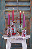 Hand-made festive candlesticks made from bottles filled with natural materials