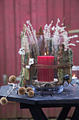Candle lantern decorated with natural materials for winter on garden table