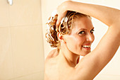 A blonde woman shampooing her hair