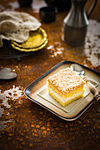 Slice of the sponge cake with lemon cheese cream and coconut shreds