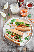 Vegan Banh mi sandwich with tofu, avocado, carrot pickles, vegan mayo and sriracha