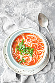 Tomato soup with noodles and chopped parsley