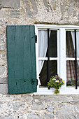 Wildblumenstrauss am Fenster einer Almhütte