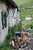 Firewood, axe and wheelbarrow outside Alpine cabin
