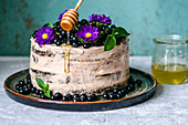 Naked Cake mit Traubenkirschen, Blumen und Honig
