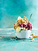 Ice cream with pretzels, crisps and popcon in a bowl