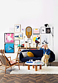 Blond woman sitting on blue sofa, framed artwork on wall