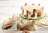 Weihnachtliche Mascarpone-Holunder-Torte auf Kuchenplatte, dekoriert mit Musiknoten