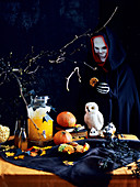 Halloween-Tisch mit Getränk, Keksen und Cupcakes