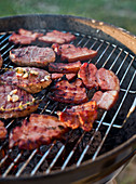Beef steaks and bacon on a grill