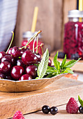 Fresh sweet cherries with drops of water on plate over wooden table