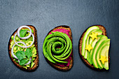 Variation of healthy rye breakfast sandwiches with avocado and toppings. toning