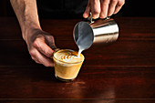 A man preparing a caffe latte