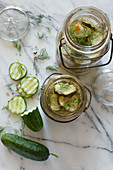 Whole and Sliced Pickling Cucumbers Marinating in Vintage Glass Jars