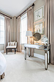 Mirrored console table in elegant bedroom in shades of grey