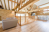 Open-plan interior below exposed roof structure in converted barn