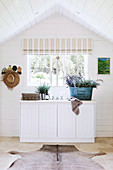 White sideboard with rural decoration on the gable window under the roof