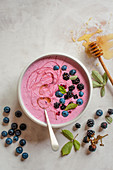 Blackberry and blueberry smoothie bowl with honey