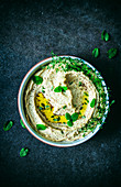 Hummus with fresh herbs and olive oil