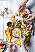 Vorspeisenplatte mit Gemüse, Oliven, Käse, Chips, Brotchips und Zwiebeldip