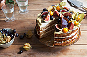 Sliced honey layer cake decorated with fresh fruits
