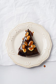 A piece of brownie cake with salted caramel and roasted peanuts