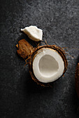 Close up image of cracked coconut on dark background